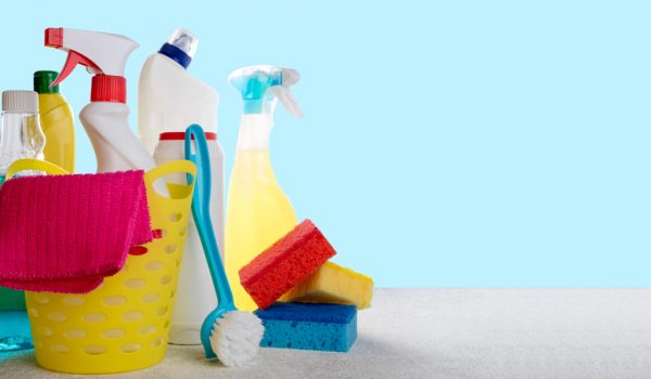 Basket with cleaning products on blue background. Cleaning with supplies, cleaning service concept. Copy space