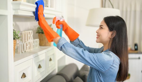A woman with cleaning gloves using alcohol spray sanitiser to cleaning house, healthy and medical, covid-19 protection at home concept .